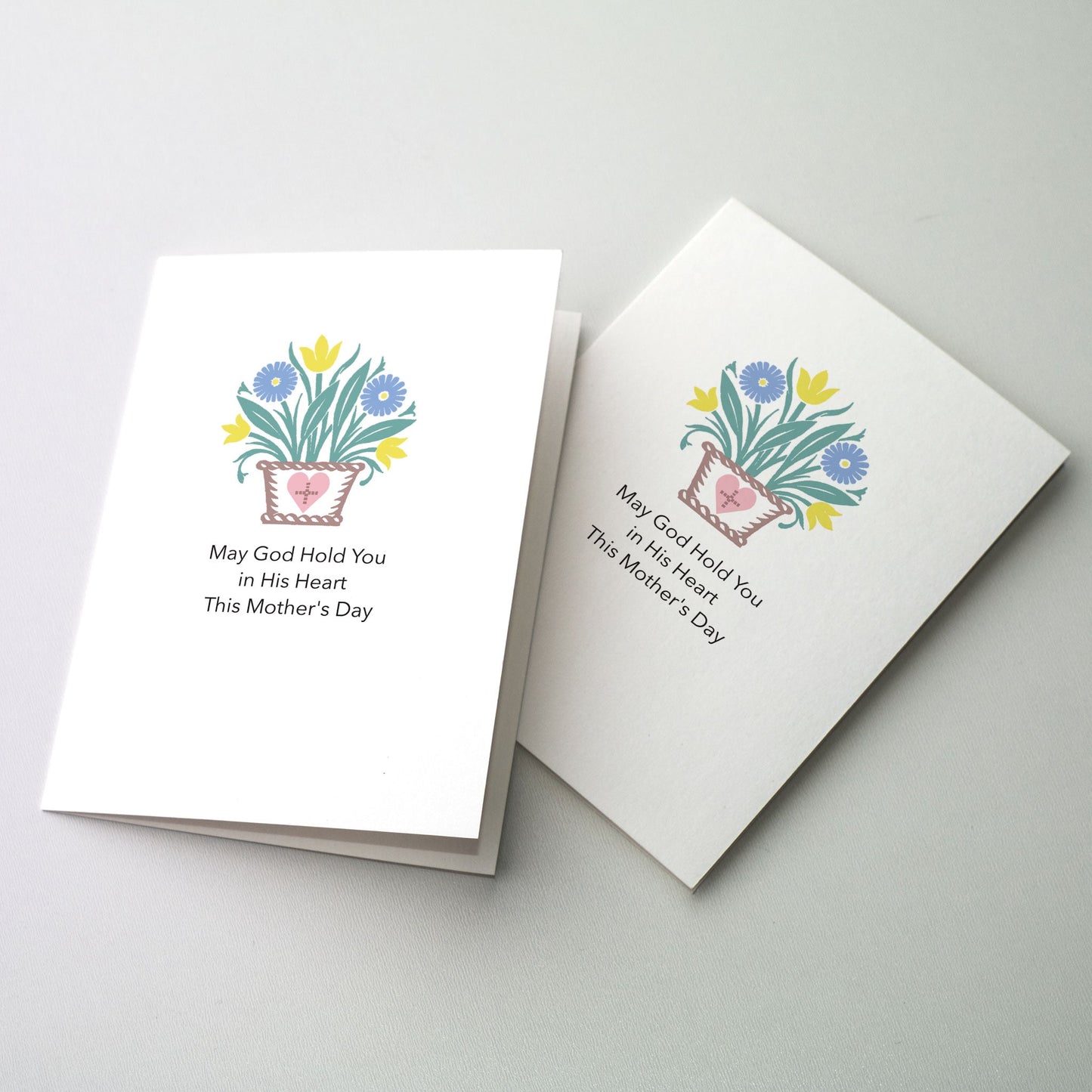 Basket of flowers with a cross upon the front. This card is intended to be given to people who cannot be with their mothers on Mother's Day, either through death or some other separation, such as a mother in prison.