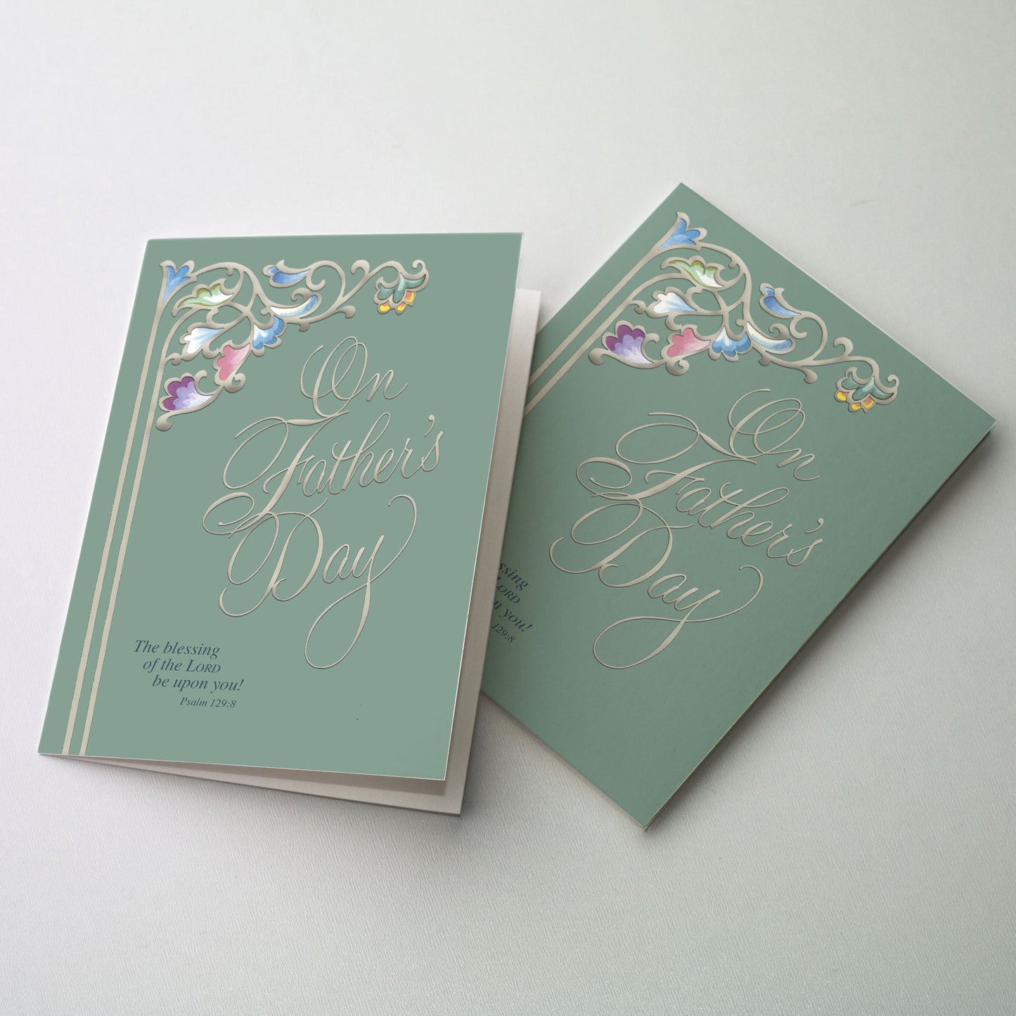 Calligraphy title and vine-like scroll with flowers are set in silver metallic ink upon a muted green ground with bible verse in left bottom corner