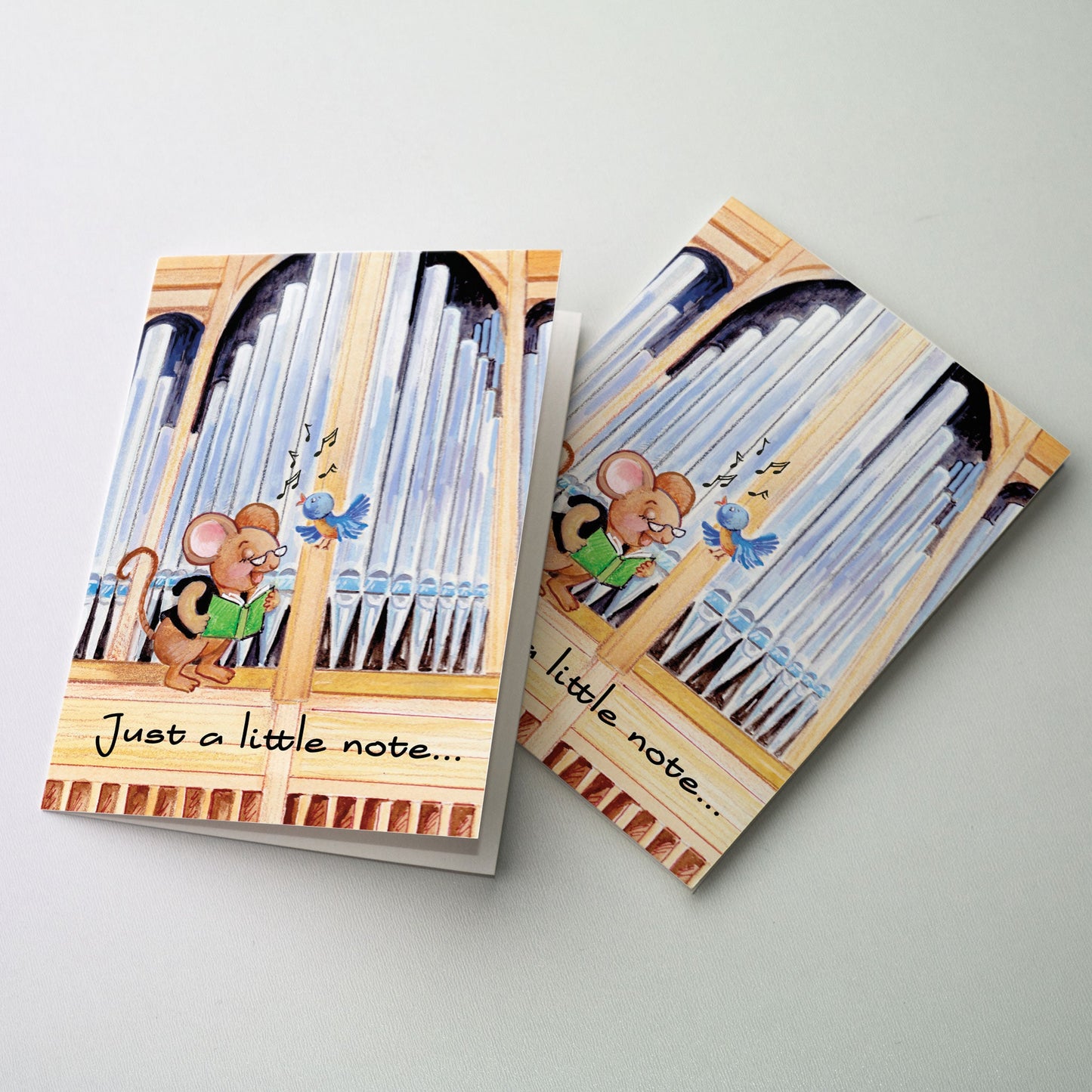 A lighthearted encouragement card intended for serious and terminal illness but also useful for a wide variety of sending situations. Benny the Church Mouse is perched in front of the organ pipes with his friend the bluebird and is singing from a green colored hymnal.