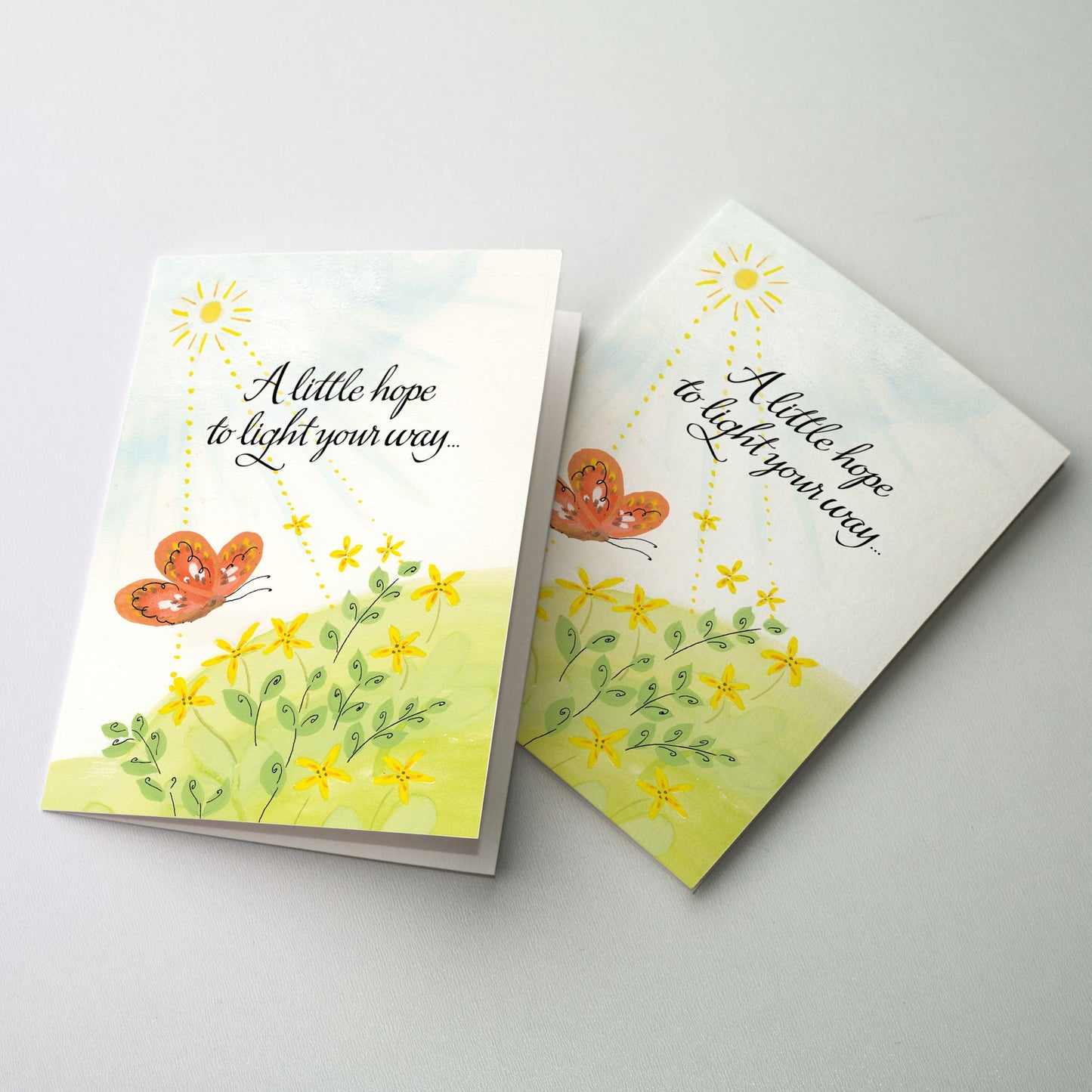 An orange butterfly hovers over yellow flowers on a grassy knoll as the sun beams down its rays.