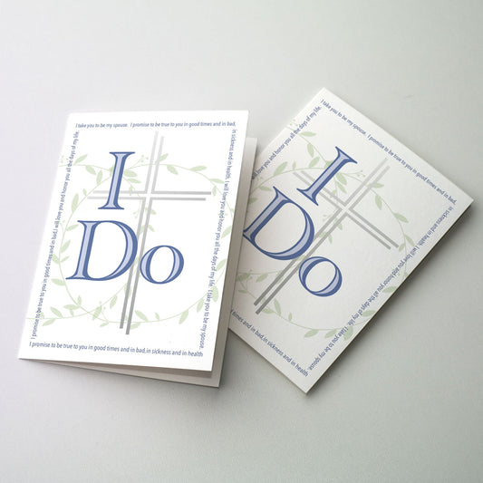 An emphasized I DO with a silver cross and interlocking leafy wedding bands surrounded by wedding vows in print.