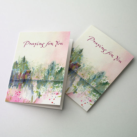 Watercolor image of trees reflecting in a pool of water. The sky above is of soft shades of pink and yellow.